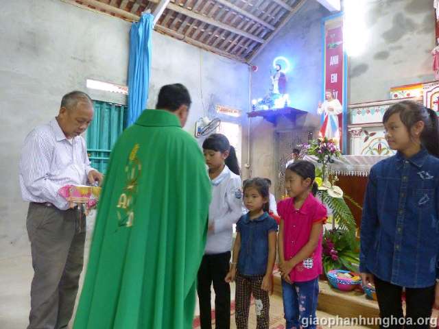 Cha xứ Giuse NGuyễn Văn Hạnh trao phần thưởng cho các em