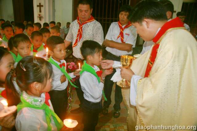 Cha chủ tế trao Mình và Máu Thánh Chúa cho các em