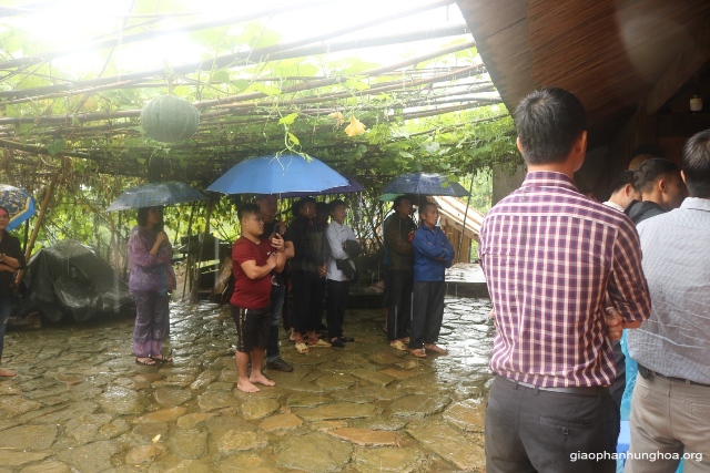 Bà con giáo dân đứng dưới mưa để tham dự Thánh lễ
