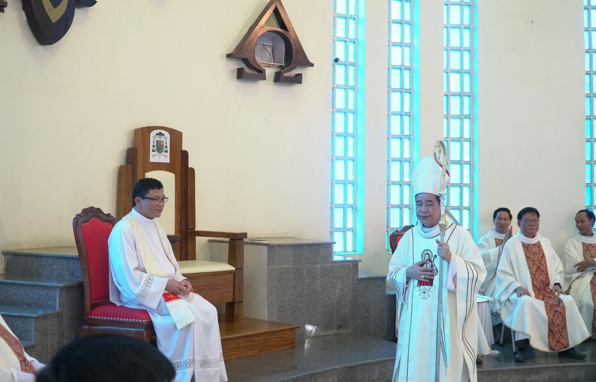 Đức Giám mục dẫn cha tân quản xứ ngồi vào ghế chủ tọa